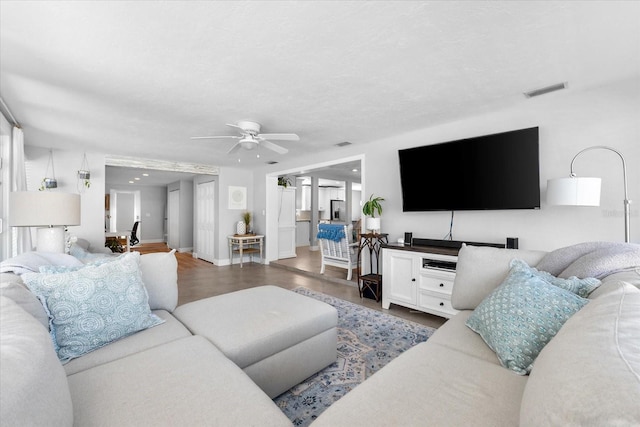 living room featuring ceiling fan and dark hardwood / wood-style flooring