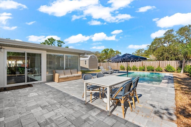 view of patio / terrace with a fenced in pool, an outdoor hangout area, and a shed