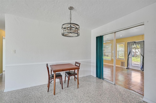 dining room with a textured ceiling and a notable chandelier