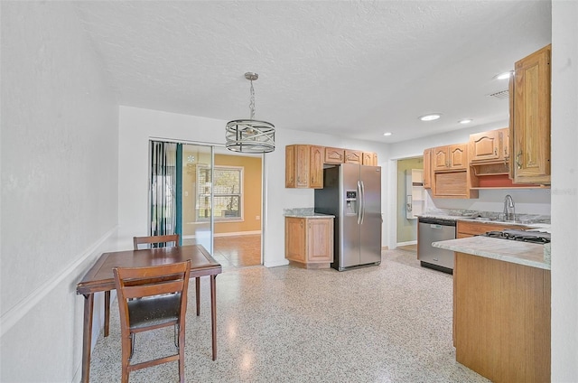 kitchen with a textured ceiling, stainless steel appliances, sink, pendant lighting, and an inviting chandelier