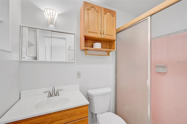 bathroom featuring vanity, toilet, and an enclosed shower