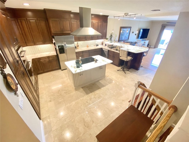 kitchen with stainless steel fridge with ice dispenser, a center island, ventilation hood, and hanging light fixtures