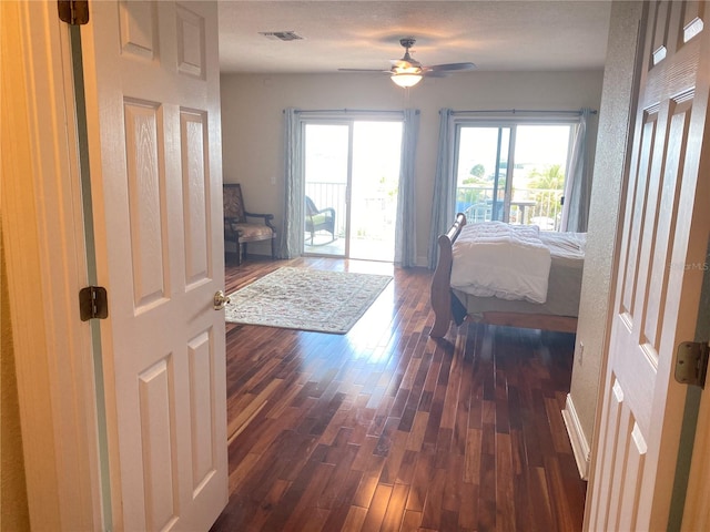 bedroom with dark hardwood / wood-style floors, ceiling fan, a textured ceiling, and access to outside