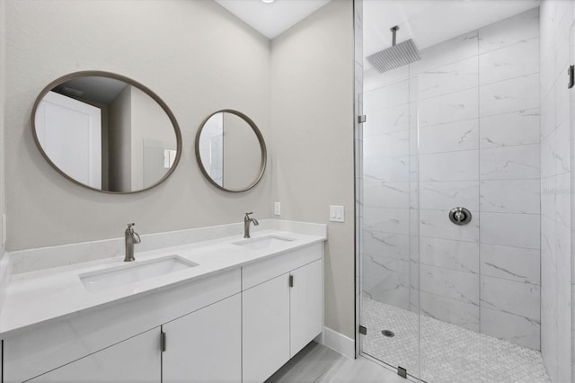 bathroom with tiled shower, hardwood / wood-style floors, and vanity