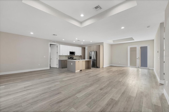 kitchen featuring sink, stainless steel appliances, a kitchen island, light hardwood / wood-style floors, and white cabinets