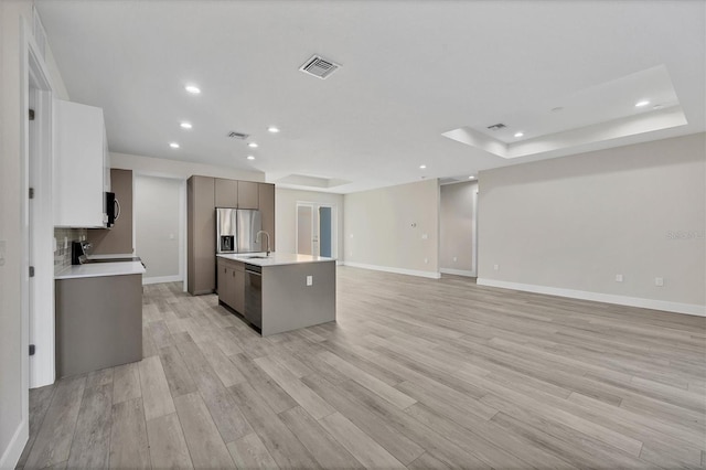 kitchen with stainless steel appliances, light hardwood / wood-style flooring, a kitchen island with sink, and gray cabinetry