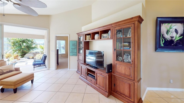 living room featuring ceiling fan, lofted ceiling, and light tile patterned flooring