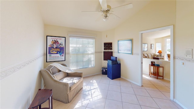 living area with ceiling fan, lofted ceiling, and light tile patterned flooring