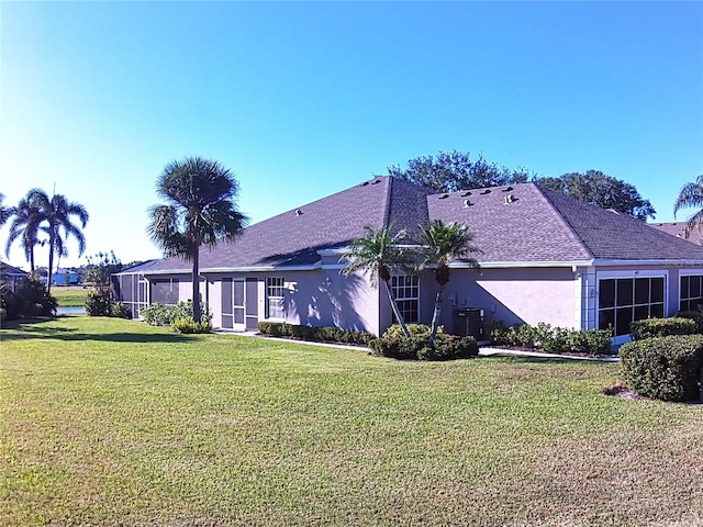 view of side of property featuring central AC and a lawn