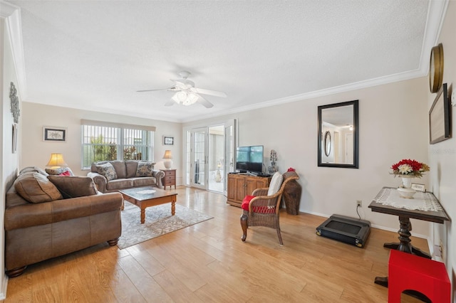 living room with a textured ceiling, light wood-type flooring, ceiling fan, and crown molding