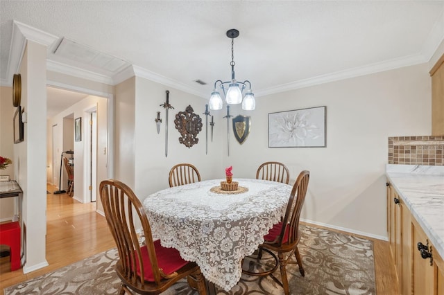 dining space with a chandelier, light wood-type flooring, and crown molding