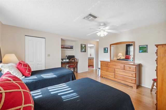 bedroom with ceiling fan, a closet, a textured ceiling, and light hardwood / wood-style flooring