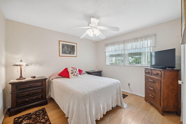 bedroom featuring ceiling fan, a textured ceiling, and light hardwood / wood-style flooring