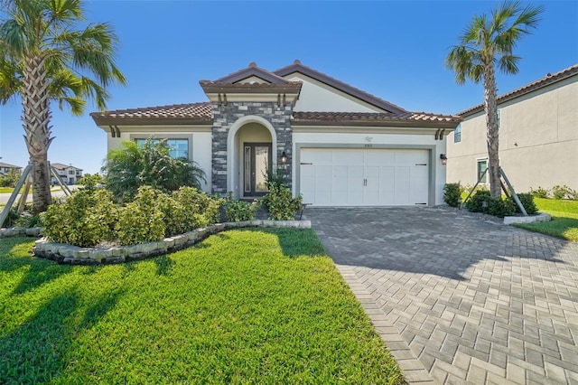 mediterranean / spanish home with a front lawn and a garage