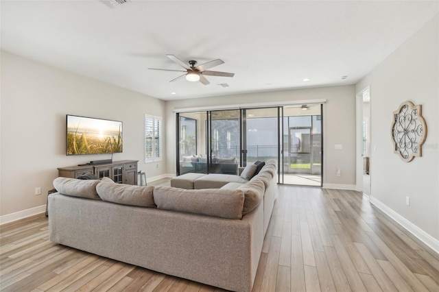 living room featuring light wood-type flooring and ceiling fan