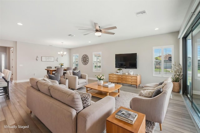 living room with light hardwood / wood-style flooring and ceiling fan with notable chandelier