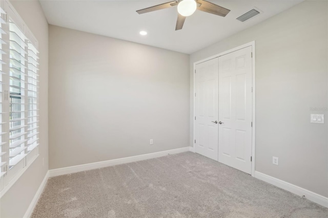 unfurnished bedroom featuring ceiling fan, a closet, and carpet floors