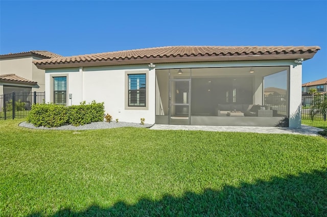 rear view of house featuring a sunroom and a yard