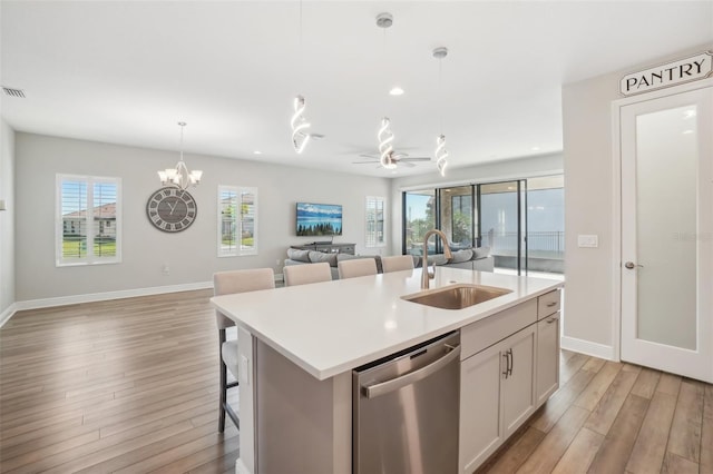 kitchen with dishwasher, an island with sink, plenty of natural light, and sink