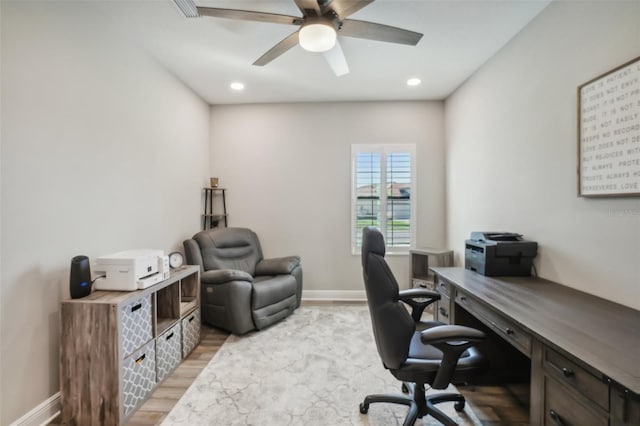 home office with light hardwood / wood-style flooring and ceiling fan