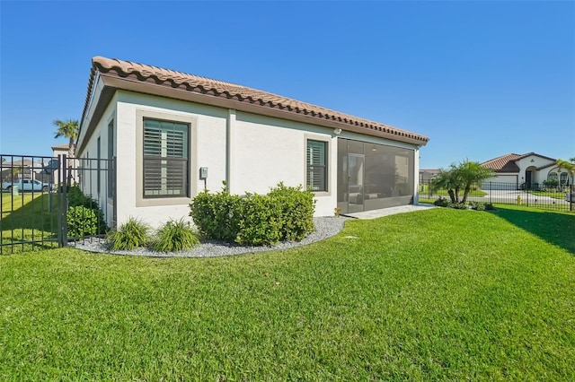 back of property with a sunroom and a lawn