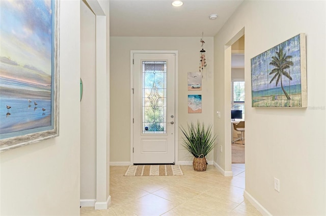 doorway with light tile patterned floors and a healthy amount of sunlight