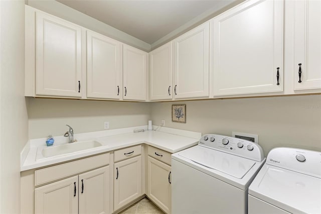 laundry room featuring cabinets, sink, and washer and clothes dryer