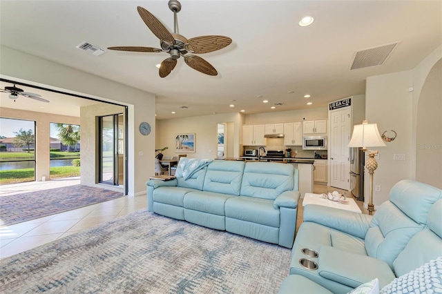 tiled living room featuring ceiling fan