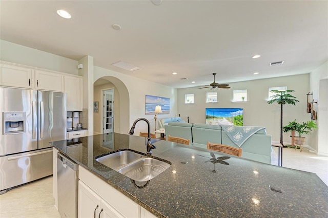 kitchen featuring white cabinetry, sink, stainless steel appliances, and dark stone countertops