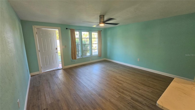 empty room featuring ceiling fan and dark hardwood / wood-style flooring