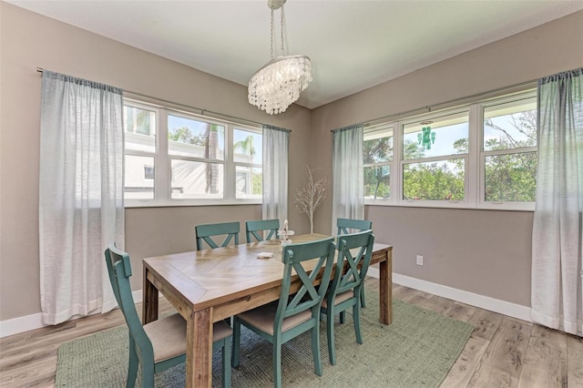 dining room with light hardwood / wood-style flooring and an inviting chandelier