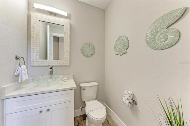 bathroom featuring hardwood / wood-style floors, vanity, and toilet