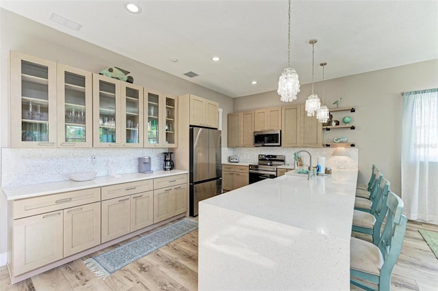 901 30th Ct E, Bradenton, FL 34208 - kitchen featuring appliances with stainless steel finishes, tasteful backsplash, a kitchen breakfast bar, open shelves, and a peninsula