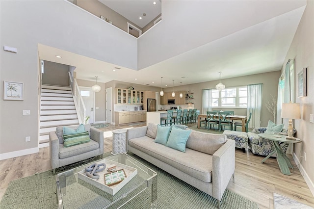 living room with a high ceiling and light hardwood / wood-style flooring