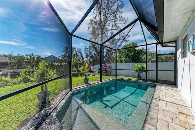 view of pool with a lawn and a lanai