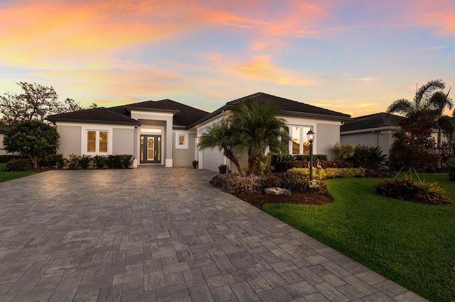 prairie-style house with a yard and a garage