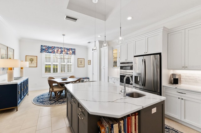 kitchen featuring a kitchen island with sink, sink, white cabinets, and stainless steel appliances