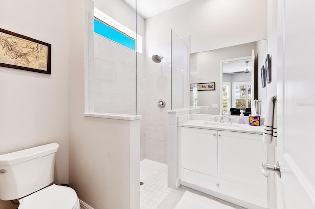 bathroom with vanity, toilet, and a tile shower