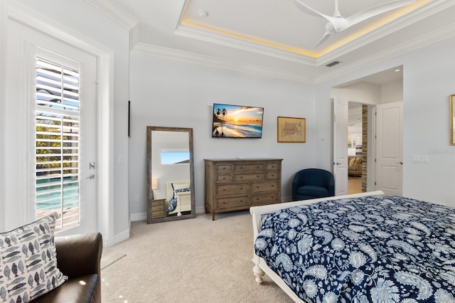 carpeted bedroom featuring a tray ceiling, ceiling fan, and ornamental molding