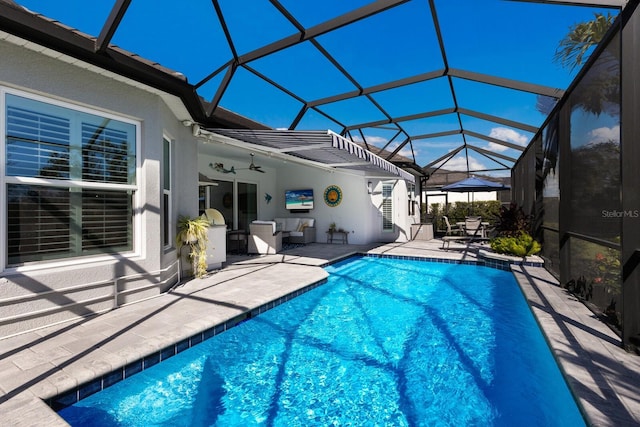 view of swimming pool with glass enclosure, ceiling fan, and a patio