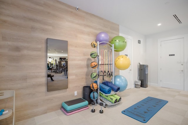 workout room featuring wooden walls