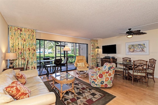 living room featuring a textured ceiling, light hardwood / wood-style floors, and ceiling fan