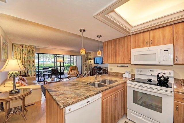 kitchen with sink, kitchen peninsula, pendant lighting, light hardwood / wood-style floors, and white appliances