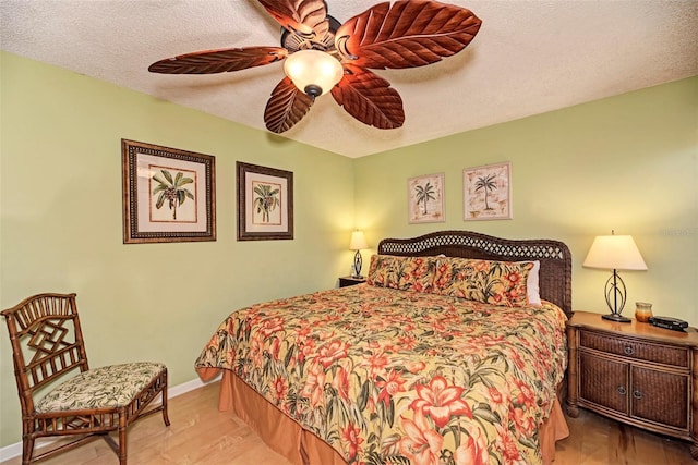 bedroom featuring a textured ceiling, light wood-type flooring, and ceiling fan