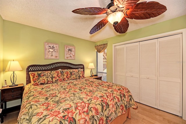 bedroom with ceiling fan, a closet, a textured ceiling, and light hardwood / wood-style flooring