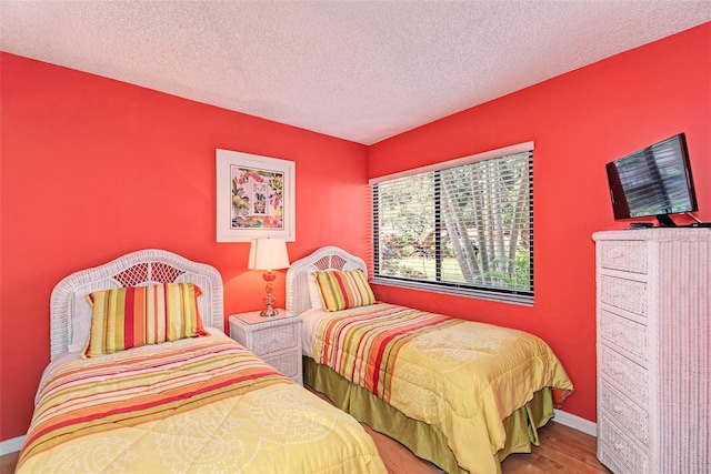 bedroom featuring wood-type flooring and a textured ceiling