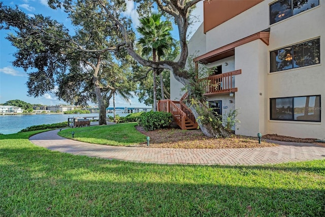 view of property's community featuring a lawn and a water view