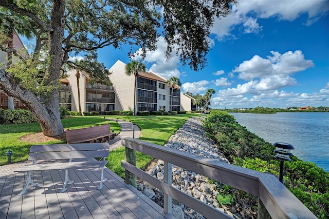 wooden deck with a yard and a water view