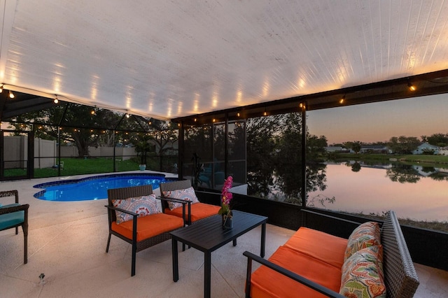 pool at dusk featuring an outdoor hangout area, a water view, a patio area, and a lanai