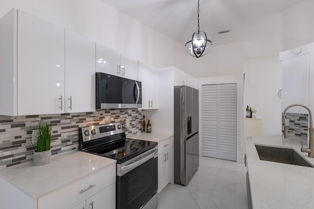 kitchen with stainless steel appliances, white cabinetry, hanging light fixtures, and sink